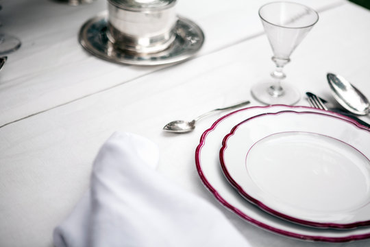 Tisch Stillife mit weissem Porzellanmit rotem Rand und silber