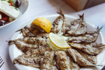 Small fried fish appetizer served with lemon