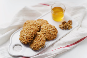 oatmeal cookies, honey and chocolate on white background. Rustic style.