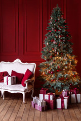 The interior of the living room in the Christmas style with a large fir-tree and Сhristmas gifts