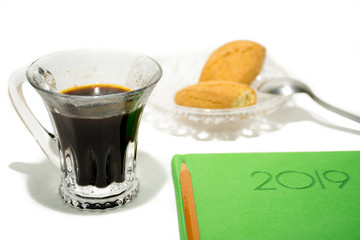 Espresso with green notebook on a white background.