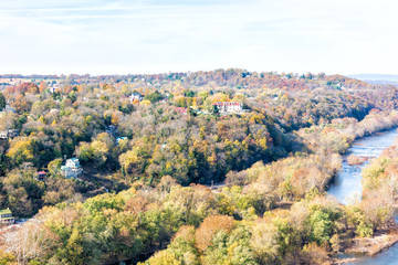 Harper's Ferry town, city near Potomac River closeup riverside with colorful orange yellow foliage fall autumn by small village in West Virginia, WV with many houses, buildings