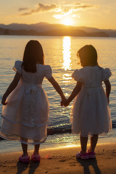  Two girls holding hands with Sunset
