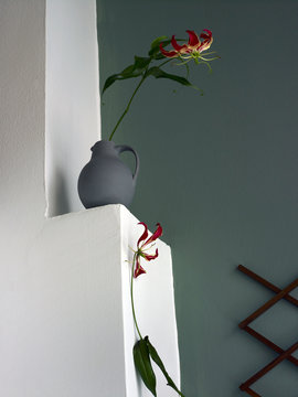 Blumen Stillife mit zwei Blumen auf Wand Sims vor gr&uuml;ner Wand