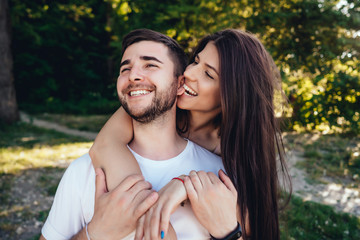 Young couple walking in the summer park.