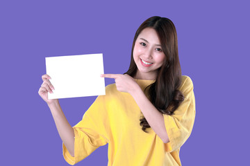 Fototapeta na wymiar Young student woman show a blank resume, yellow t-shirt clothing, purple background