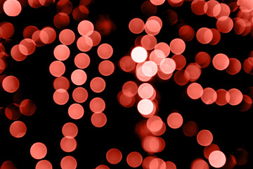 Sparkling background made of Living Coral 2019 lights. Festive blurred backdrop for holidays and parties.