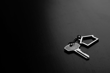 Home key with house keyring on black wood table in dark tone, real estate concept - 237573804
