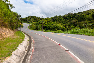 Asphalted road with bike path, with dense vegetation at the edges, connecting the beaches of Bombas and Mariscal, Bombinhas, Santa Catarina