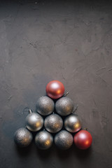 Christmas tree made by silver and pink Christmas balls on the dark background, copy space