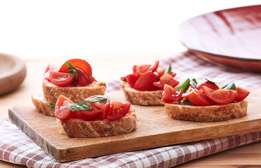 tomato bruschetta with basil on wood board