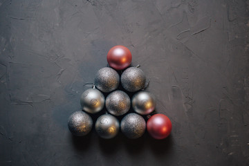 Christmas tree made by silver and pink Christmas balls on the dark background, copy space