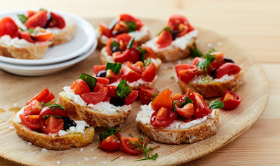 tomato and cheese bruschetta wood dish on table