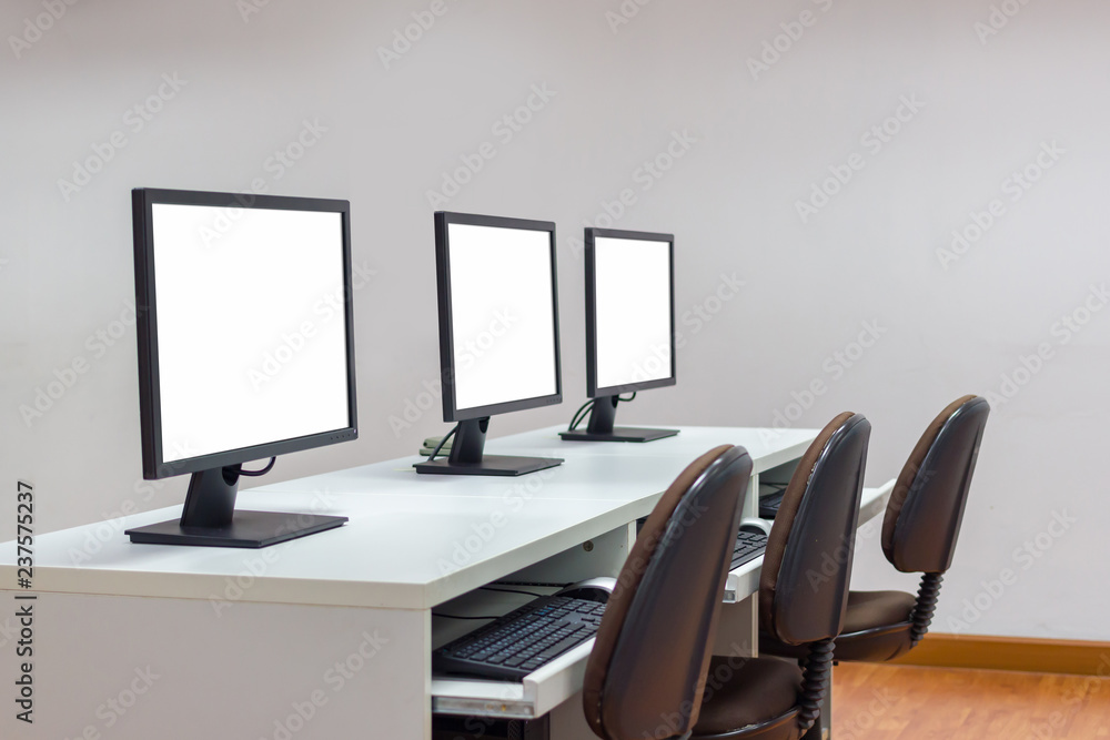 Poster row of three white screen monitors on desk with keyboard.selective focus image with copy space.clipp