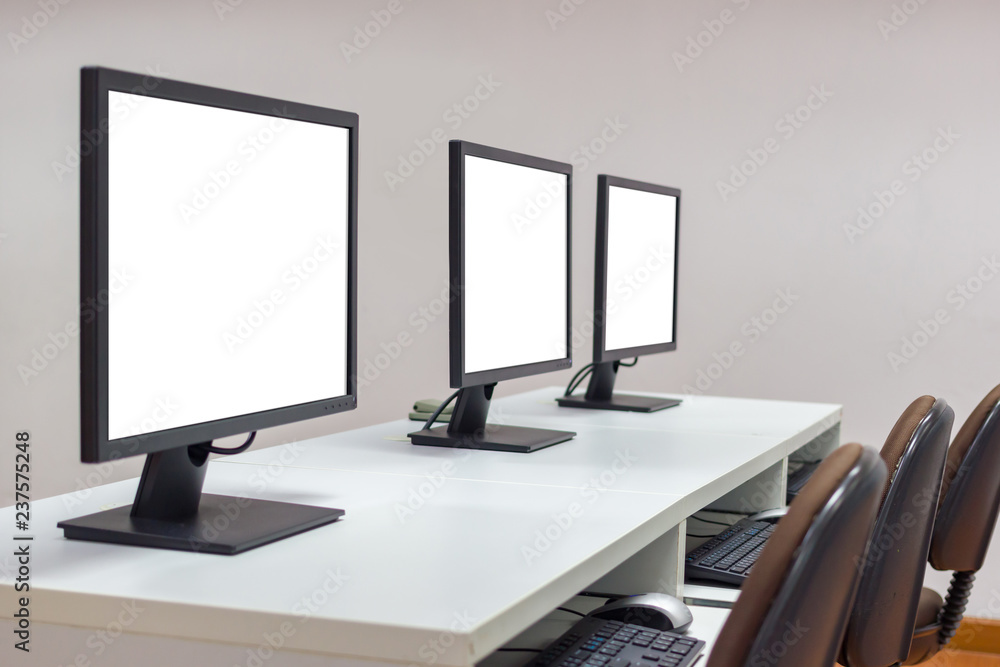 Poster row of three white screen monitors on desk with keyboard.selective focus image with copy space.clipp