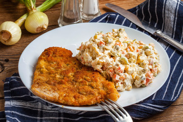 Fried pork chop in breadcrumbs, served with vegetable salad.