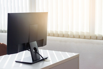 back side of monitor on desktop with window sun light.Image with copy space.
