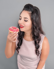 Happy plus size woman with donut. Body positive concept