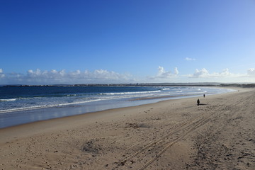 Beach with people walking on sand