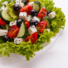 Greek salad on a white acrylic background