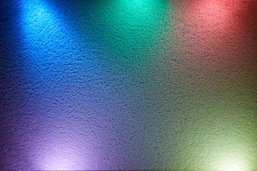 Rays of different colors light up the wall