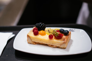 On the table is a plate with cheesecake.
