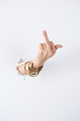 cropped image of woman holding hand with bracelets through white paper and showing middle finger