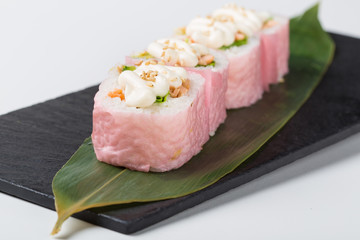 Set of pink maki sushi served on leaf