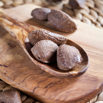 Olive wood with Brazil nuts - copy space on wooden board . Brazil nuts are good source of protein and omega 3. Nuts are important to a balanced, healthy, vegan, plant based diet.