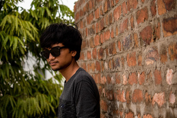 Fototapeta na wymiar Portrait of young man in front of brick