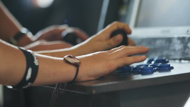 Male hands touching blue buttons, completing levels in videogame. Entertainment concept, idea. Game arcade machine. Without face.
