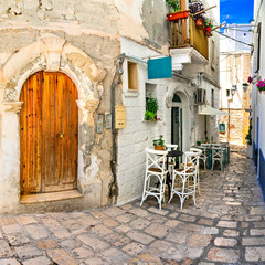 Traditional narrow streets with bars in white town Monopoli,Puglia. South of Italy