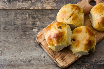 Traditional Easter hot cross buns on wooden table. Copyspace