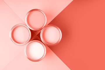 Banner with color of the year 2019 - Living Coral. Four open cans of paint on bright symmetry...