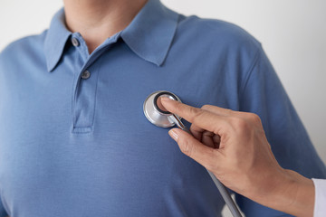 Fototapeta premium Close-up image of doctor checking heartbeat of male patient