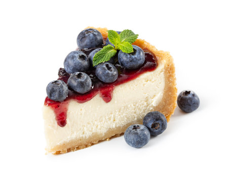 Piece of cheesecake with blueberries and mint isolated on white