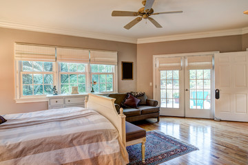 Tasteful bedroom interior with hard wood floors and french doors