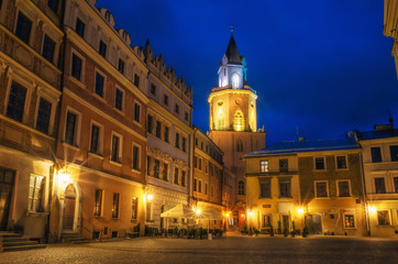 Fototapeta na wymiar Market with The Archdiocesan Museum of Religious Art in The Trinitary Tower in Lublin old town at night, Poland