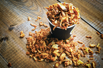delicious fried onion slices on wooden background