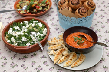 Chicken with roasted pepper sauce, roasted aubergine, feta cheese salad and tapenade bread served on a table. Selective focus.