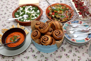 Chicken with roasted pepper sauce, roasted aubergine, feta cheese salad, tapenade bread rolls and tiramisu served on a table. Selective focus.