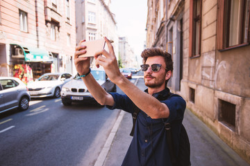 Tourist man taking selfie with smartphone