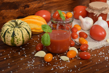 tomato juice in a glass with basil, cherry tomatoes, garlic, spices preparations for winter
