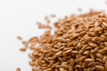 Seeds of golden flax on a white background
