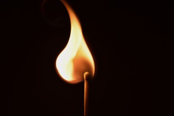 Ignition Orange flaming matchstick on black background