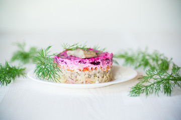 layered salad of boiled vegetables with beets and herring
