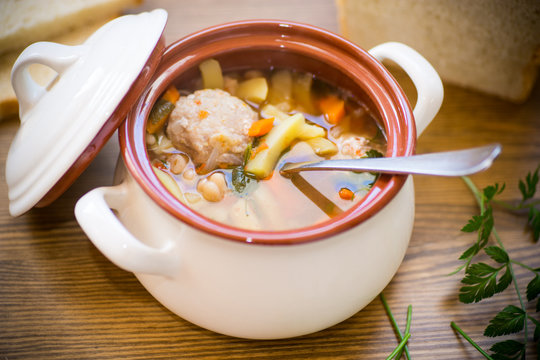 vegetable soup with beans and meatballs in a ceramic bowl