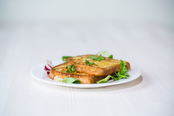 fried croutons in eggs with greens in a plate