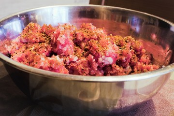 Minced meat for meatballs in a stainless steel bowl.