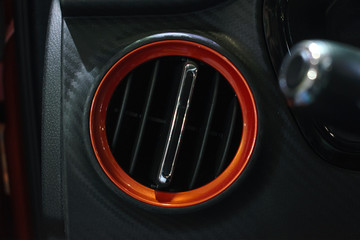 Obraz premium Car air ventilation, conditioner in orange circle. Ventilation deck in luxury modern car interior.